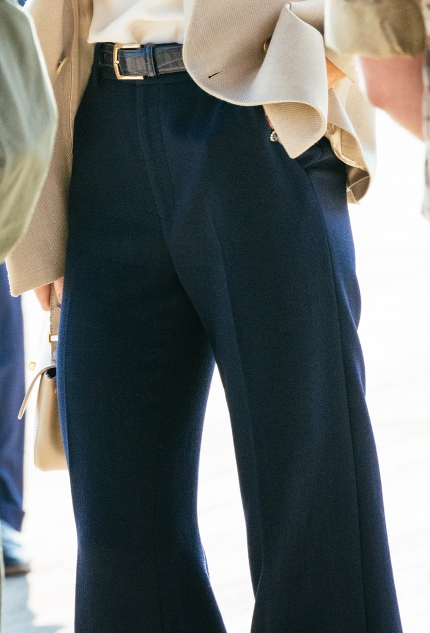 Kate wears navy croc embossed belt and navy wide-leg trousers